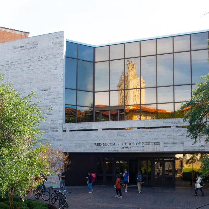 McCombs entrance with a reflection of UT Tower in windows as seen from the north side