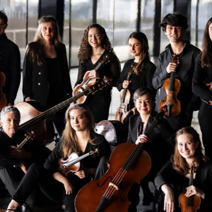 Les Arts Florissants and Théotime Langlois pose for a group image holding their stringed instruments