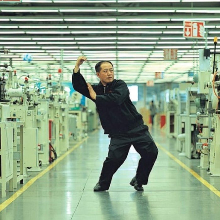 A man strikes a pose in a factory. 