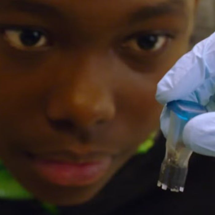 A child looks at a test tube. 
