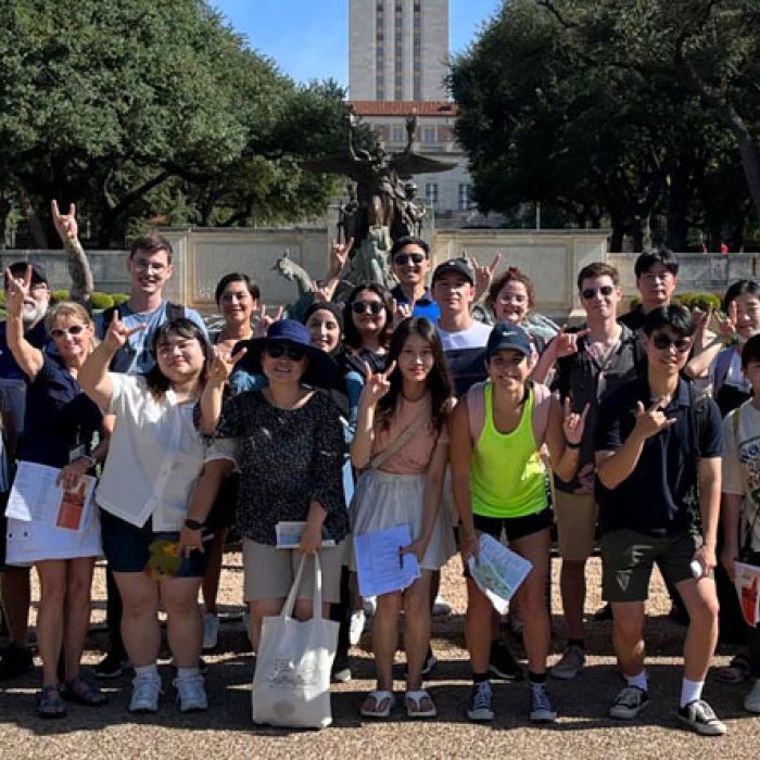 International students pose for a group photo on with the UT Tower in the background during the campus walking tour