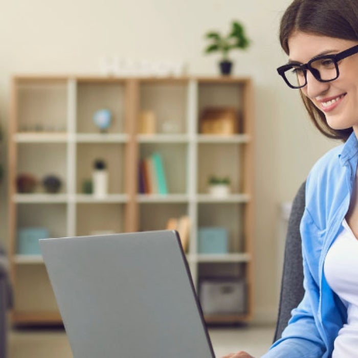 Girl saying high in front of laptop during a virtual meeting