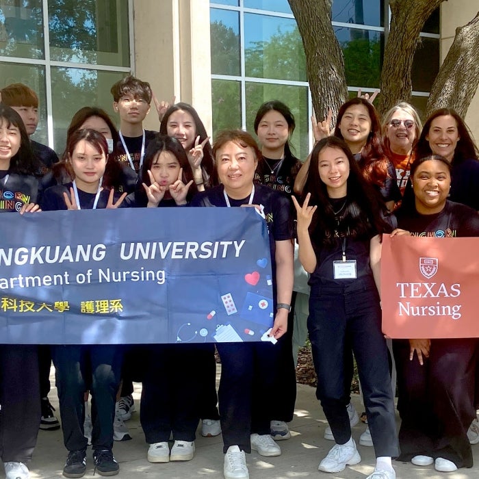 A group from Hungkuang University poses outside on the UT Austin campus