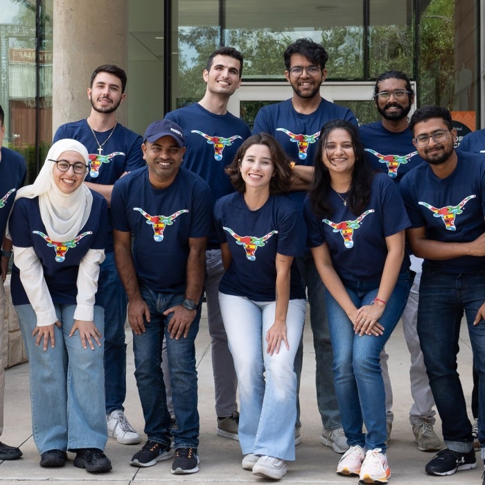 A group of ISSS students smile in front of the Texas Global main building