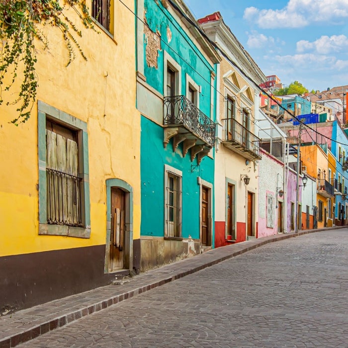 Colorful homes line a cobblestone street in a spanish country