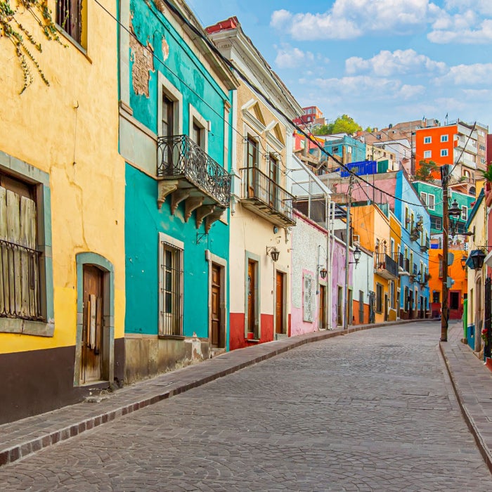 Colorful homes line a cobblestone street in a Spanish country