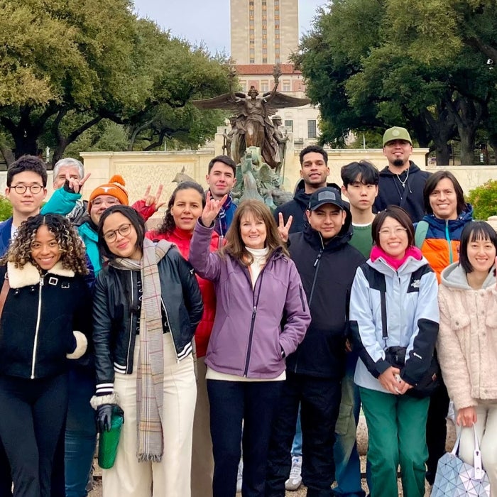 A group photo in front of the Littlefield fountain with the UT Austin Tower in the background