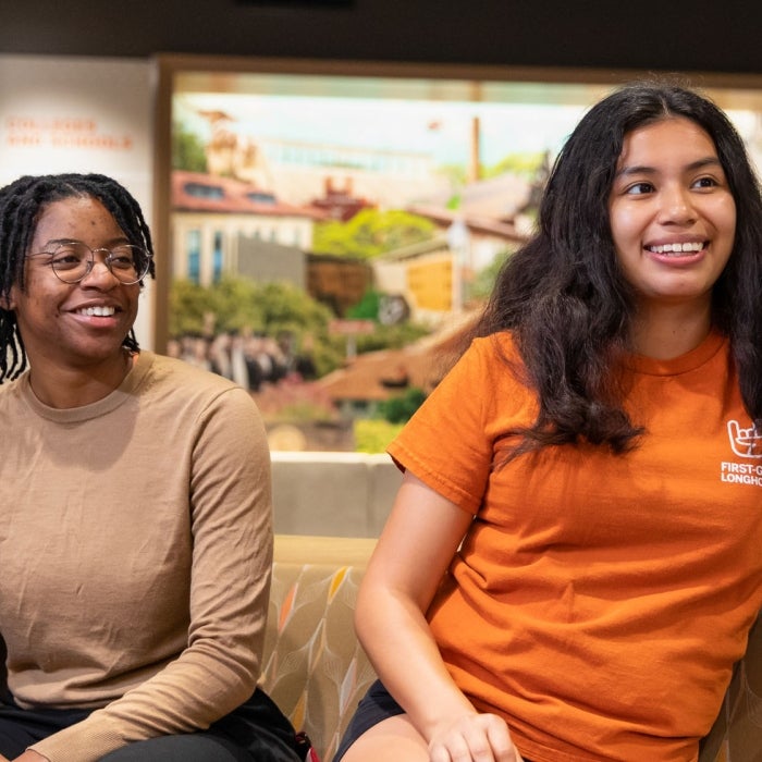 UT Students sit together and smile in discussion with one another