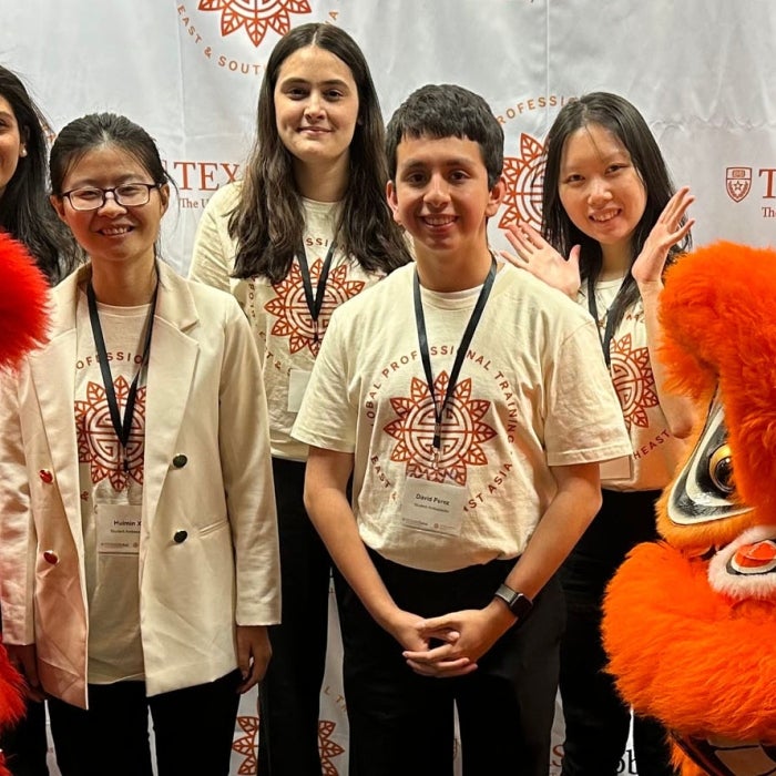 Smiling group of student ambassadors at GPT Asia with dragon dancers