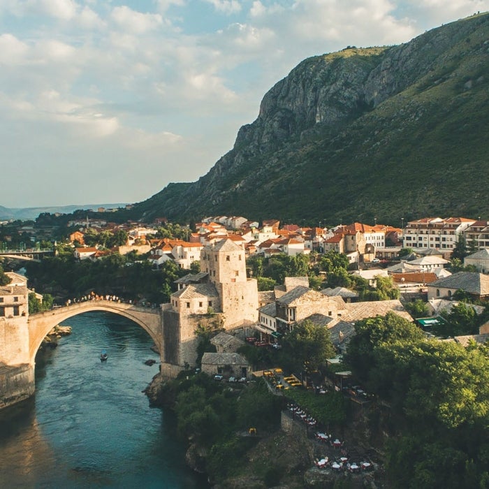 Two sides of Mostar, city connected by bridge with river in the middle in Bosnia and Herzogovia
