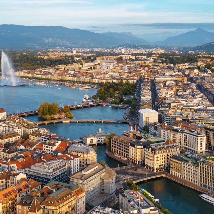 Skyline view towards the Jet d'Eau fountain in Lake Geneva with mountains in the background in Geneva, Switzerland