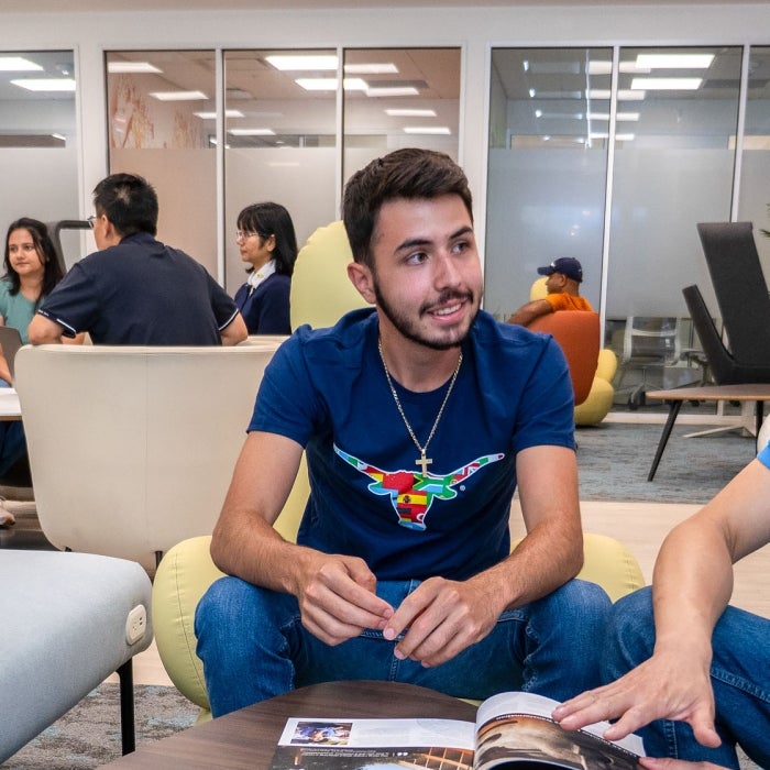Students sit together in the Texas Global lobby engaged in discussion