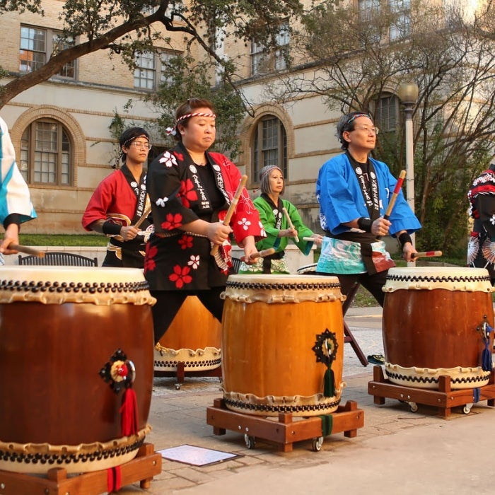 Austin Taiko drummers performing outside on campus at UT Austin