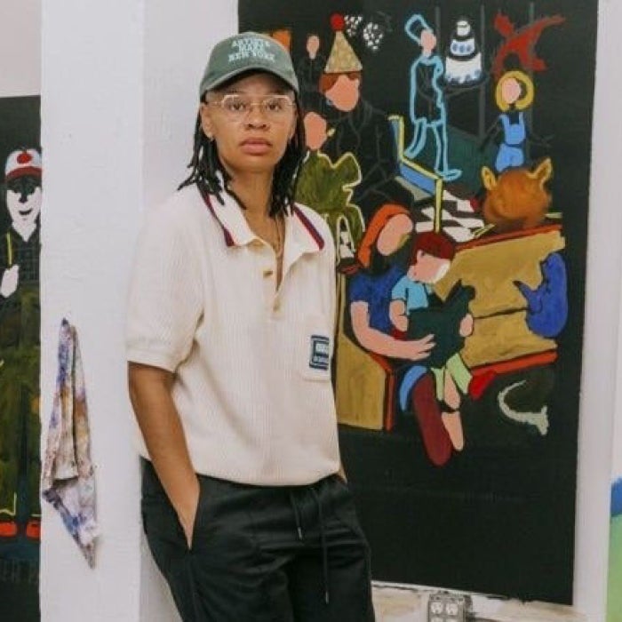 An artist poses with her work
