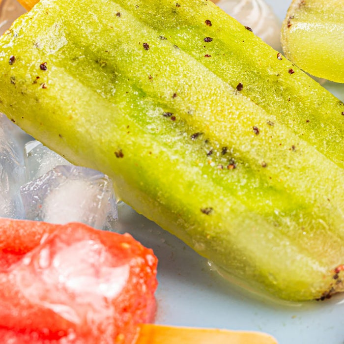 yellow red and green fruit-based icepops are displayed on top of ice