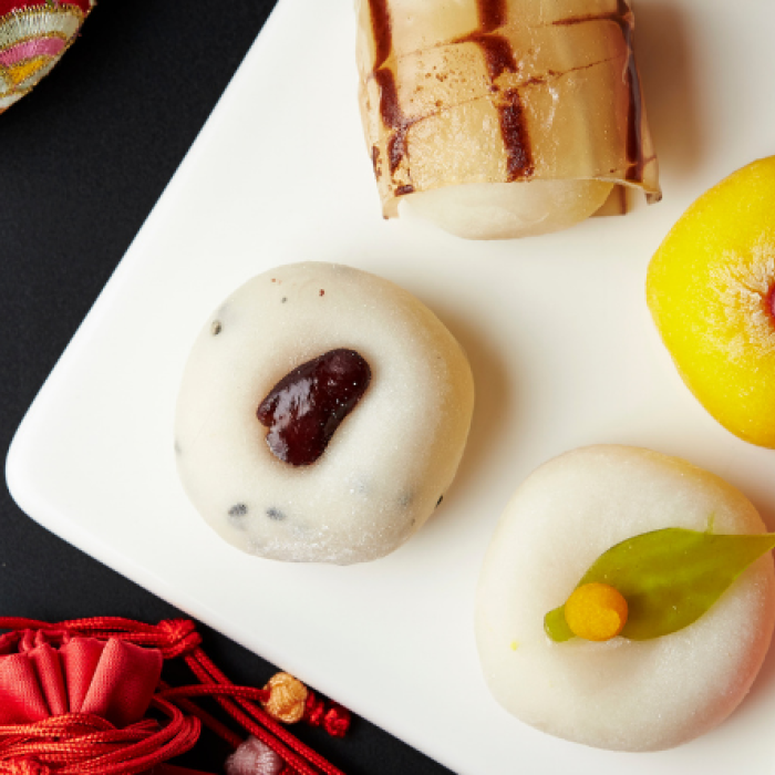 Chuseok celebration items including mochi, satin slippers, and colorful cloth