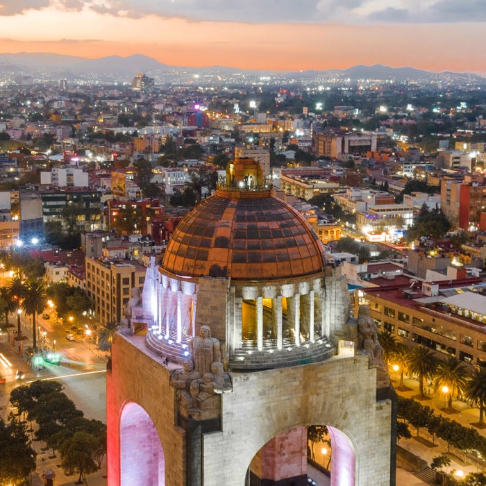 Aerial view of city center in Mexico City, Mexico, including historical landmark Monument to the Revolution located at Republic Square at dusk