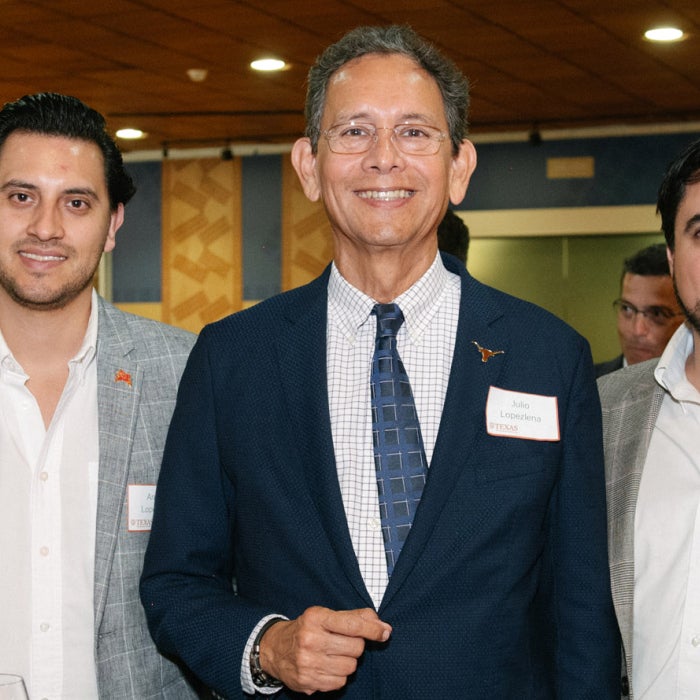 UT Texas Global alumni smile in a group photo together at an alumni event