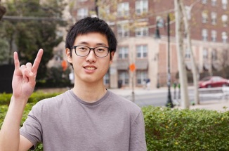 UT student Chen Pang Chan poses with hook'em horns hand sign 