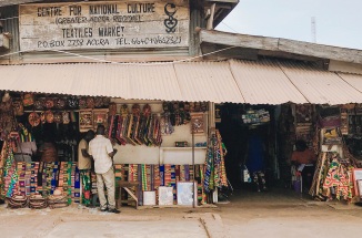 shoppers walk through a market in ghana