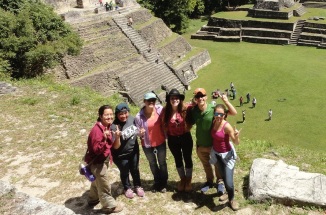 students pose next to ancient temples in central america