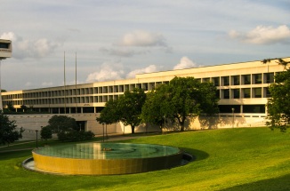 large building with trees and fountain in front