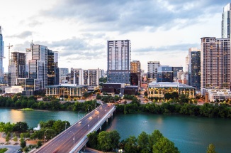 a view of the austin skyline and river at sunset
