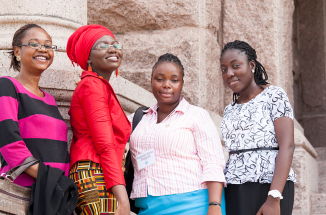 four women stand in front of the texas capitol 