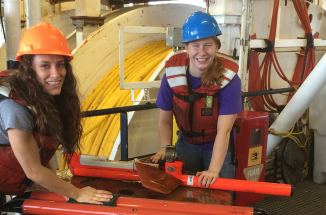 Jackson School of Geosciences graduate students wear hard hats/vests and are surrounded by machinery as they explore plate boundaries.