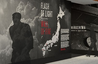 Human shadows walk by the photo exhibit Flash of Light, Wall of Fire at the Briscoe Center for American History