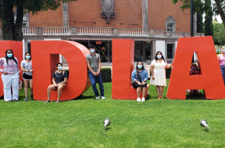 students stand in front of giant red letters reading "UDLAP"