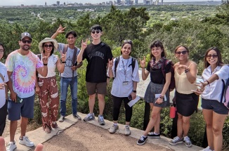 Will Slade and students smile with Austin's greenbelt and downtown skyline in background