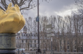 Olympic flame against cloudy Parisian sky