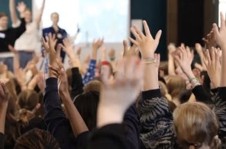 Hands go up in a classroom using Drama for Schools, a UT program