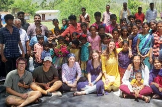 Volunteers from Projects with Underserved Communities pose with community members in India