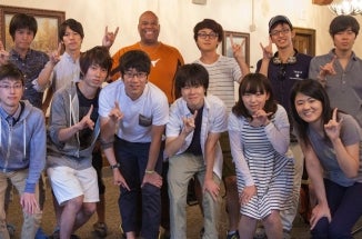 ELC students from Hitosubashi University smile and throw a "Hook 'em"" sign.