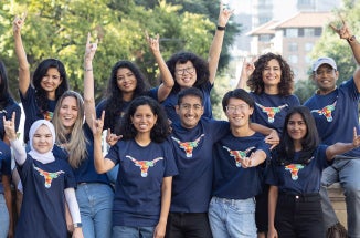 UT international students throw the Hook 'em Horns sign