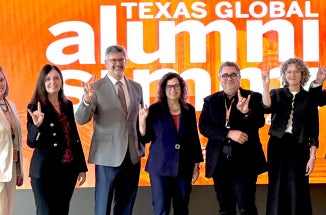 Deans and leaders from UT Austin show "Hook em" at the 2026 Alumni Summit