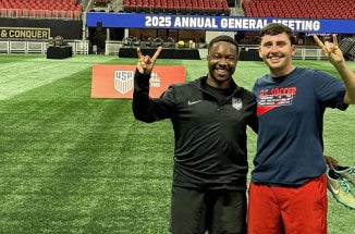 Two men hold up a "hook 'em" hand sign at the World Cup.