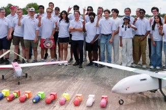 UT Austin's team for the XPRIZE Wildfire Competition stands behind the planes they built
