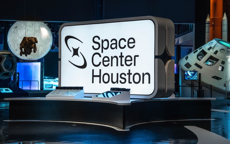 A sign for the Space Center of Houston illuminates the entryway