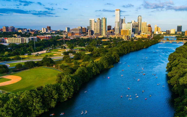 Austinites cool off on Lady Birdy lake with the Austin city skyline in the background