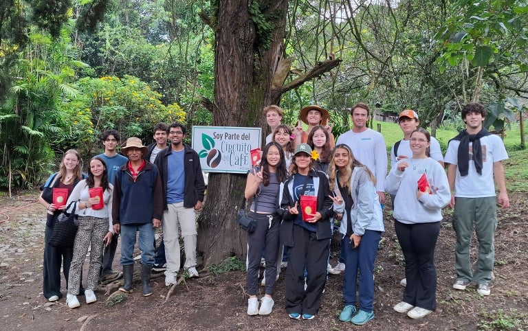 A Panama study abroad group poses at a care in the jungle