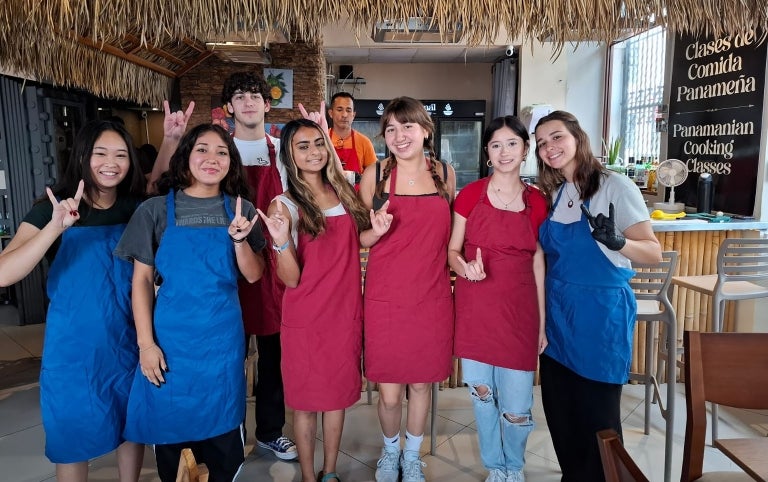 A female group of study abroad students smile at a cooking class in Panama