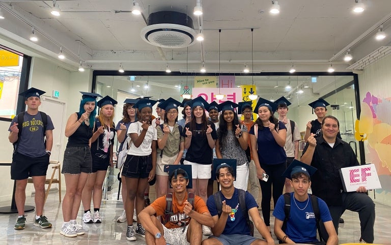 A student group poses with graduation caps while abroad in South Korea