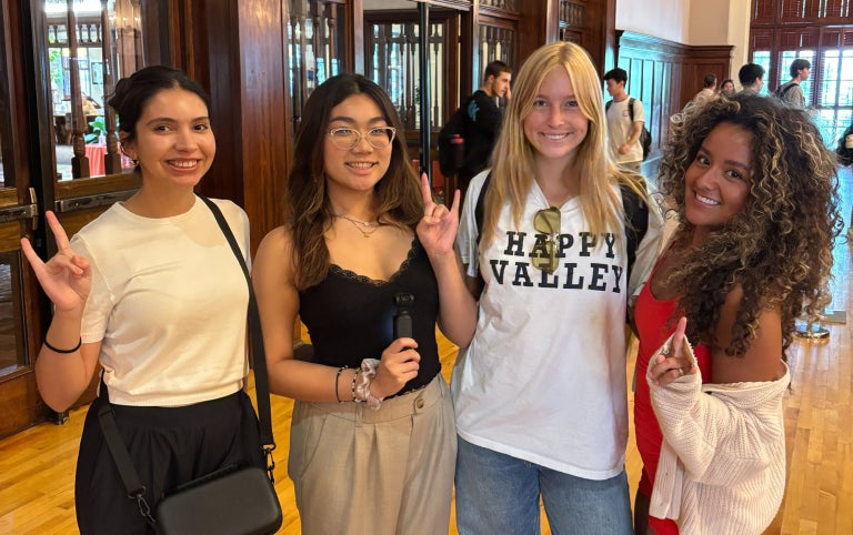 Students posing at Education Abroad Fair displaying the hook'em hand sign