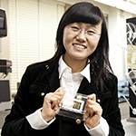 Smiling female student holding glass award.