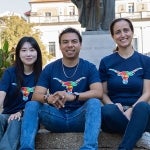 Diverse english language students smile and pose on campus wearing blue texas global shirts
