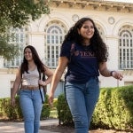 Students walk under live oaks during the day on the beautiful UT Austin campus