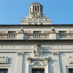 the classically styled main building is shown with the UT Tower rising up behind it